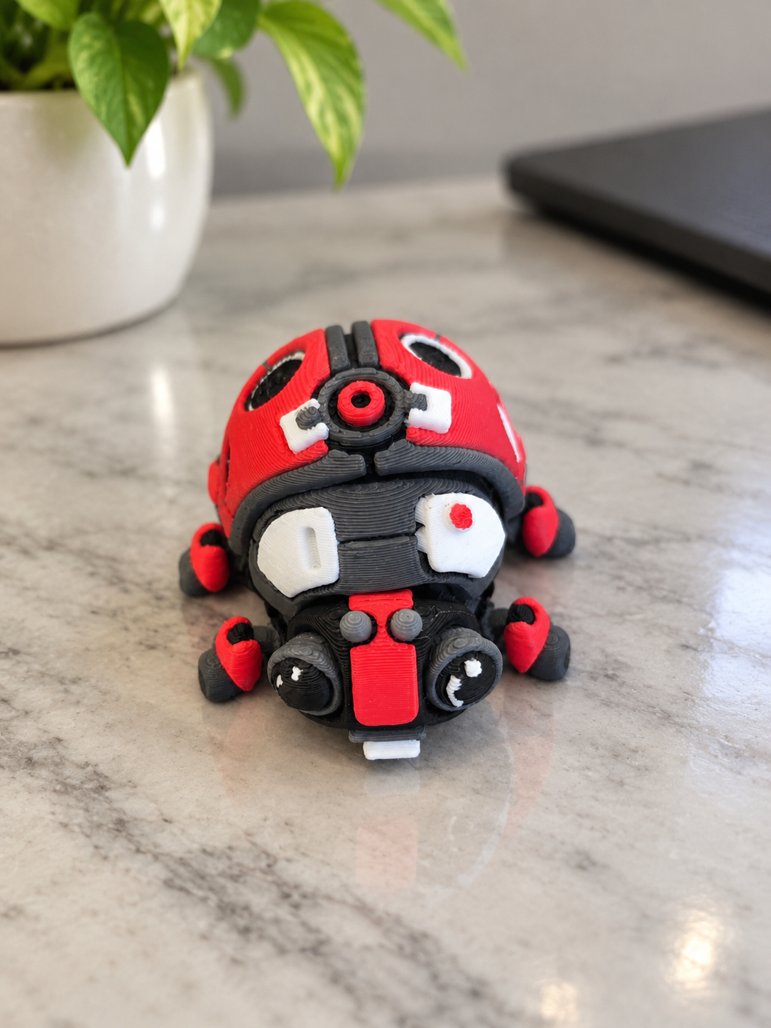 Ladybug-shaped clicker toy with red, black, and white details on a marble surface, branded by DJM 3D SHOP.